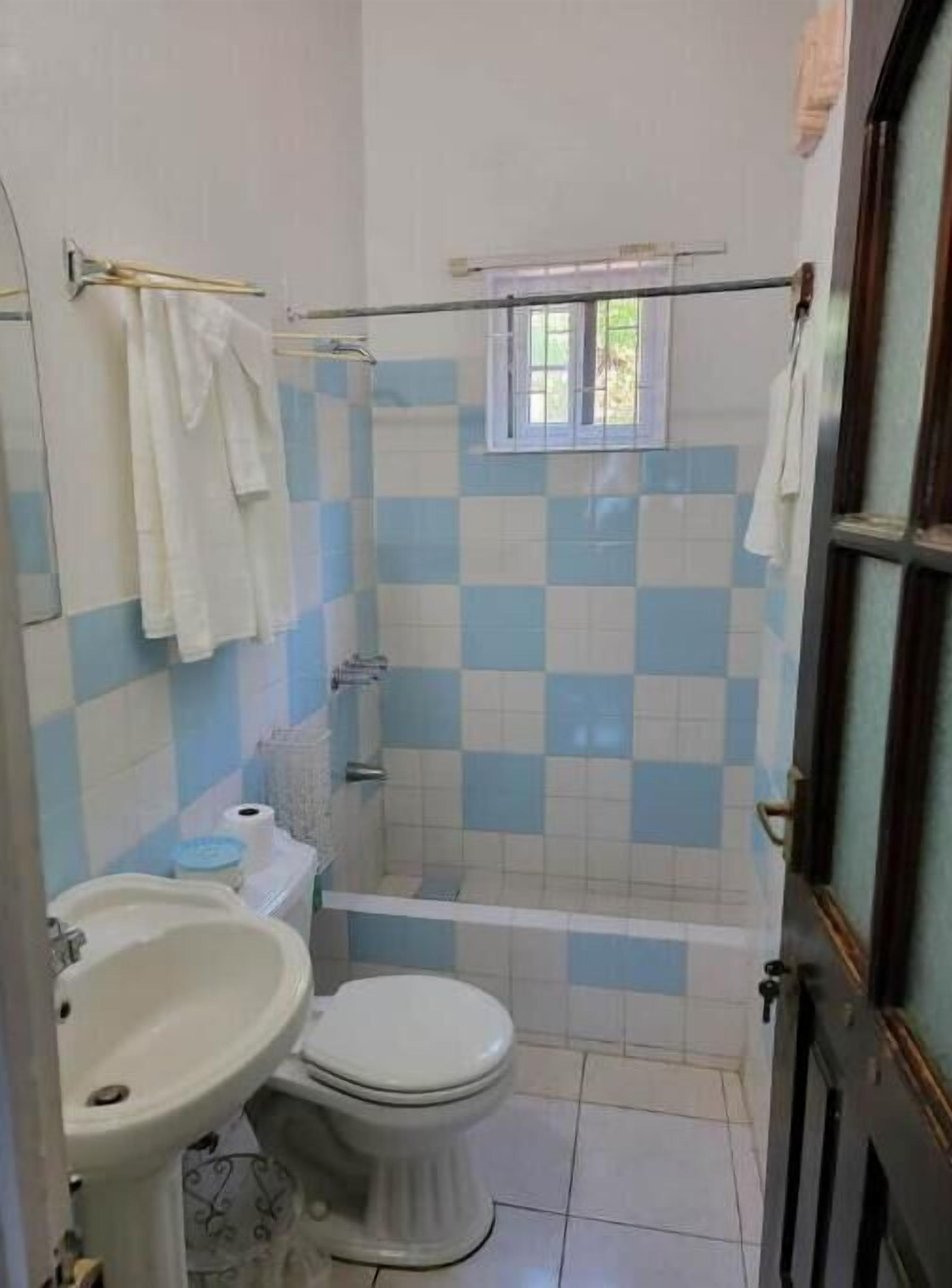 A bathroom with a toilet, sink, and shower.