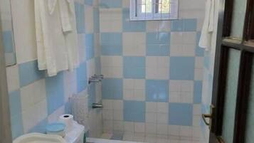 A bathroom with a toilet, sink, and shower.