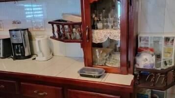 A kitchen with wooden cabinets, a coffee maker, a toaster, and a refrigerator.