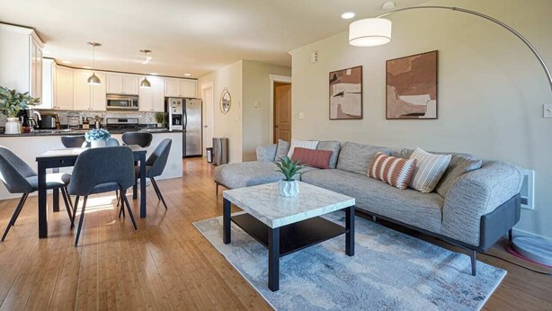 Een moderne woonkamer met een bank, salontafel en een eethoek.