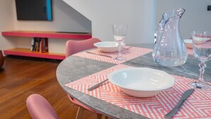 A dining table with pink and gray placemats, white plates, and clear glassware. - Elegant Home With Sauna by Wonderful Italy (Turin)