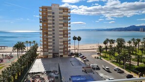 A high-rise hotel with a view of the beach and ocean.