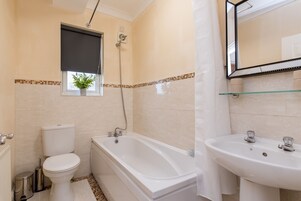 A bathroom with a toilet, bathtub, and sink.