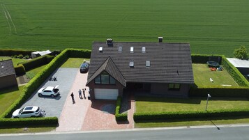 A two-story house with a tiled roof, a garage, and a driveway.