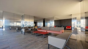 Un espacio de oficina moderno con una mesa grande para todos, varias sillas y un sofá.