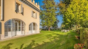 A building with arched windows and a well-maintained lawn. - Luxury Villa - Unesco Monferrato Langhe Roero with private pool (Asti)