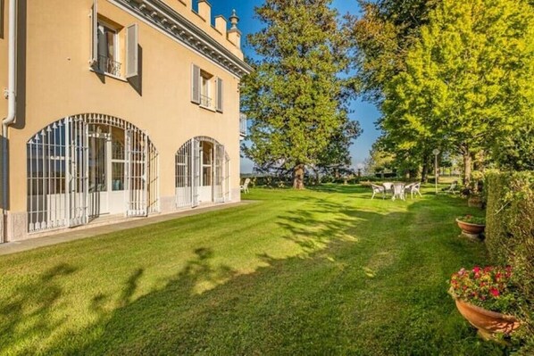 A building with arched windows and a well-maintained lawn. - Luxury Villa - Unesco Monferrato Langhe Roero with private pool (Asti)