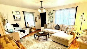 A living room with a sofa, a coffee table, and a dining table. - Ridgeway Bed & Brksfst Suite, Full Kitchen, Slps 4 (Eureka Springs)