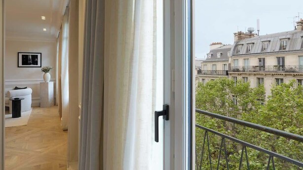 A corridor leading to a balcony with a view of Parisian buildings. - The Lander - Serviced 3BR/3BA - Champs-Elysées (Paris)