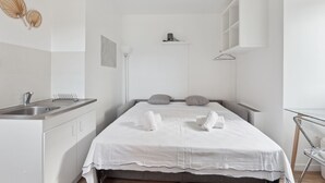 A modern, minimalist bedroom with a bed, bedside table, and a built-in wardrobe. - ID 412 - Beaugrenelle / rue Gaston de Caillavet (studio) (Paris)