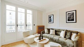 Un salon comprenant un canapé, deux fauteuils, une table basse et un buffet.