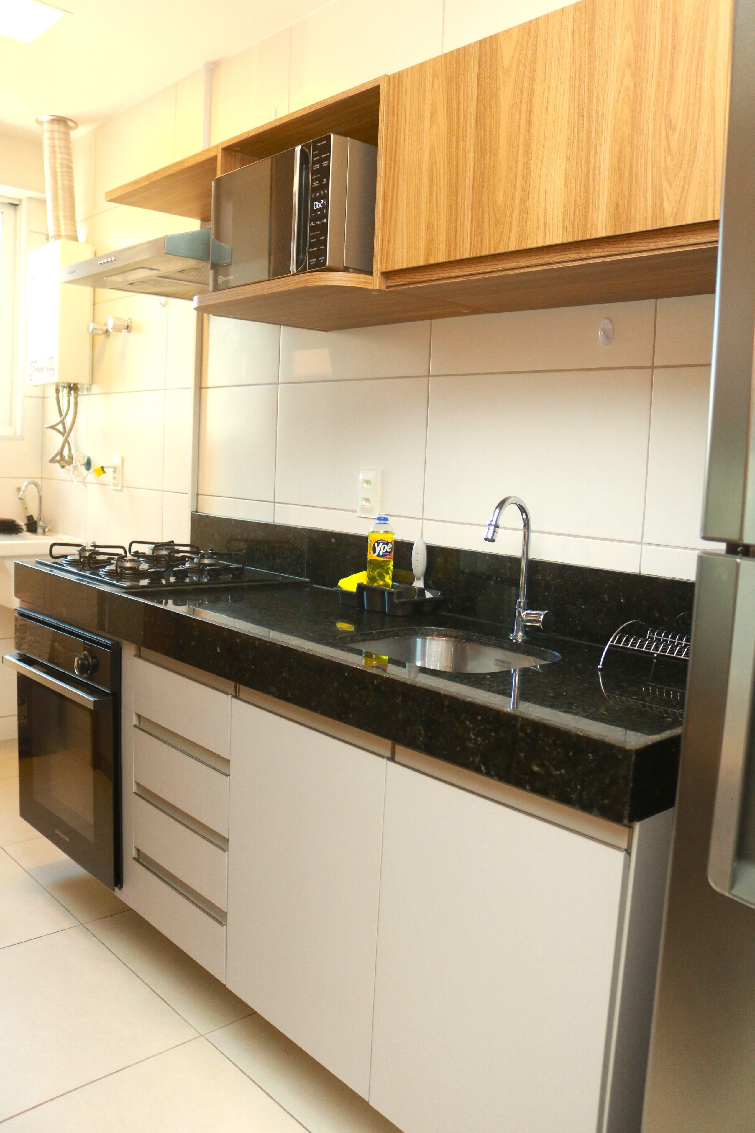 A kitchen with a stove, oven, sink, and wooden cabinets.
