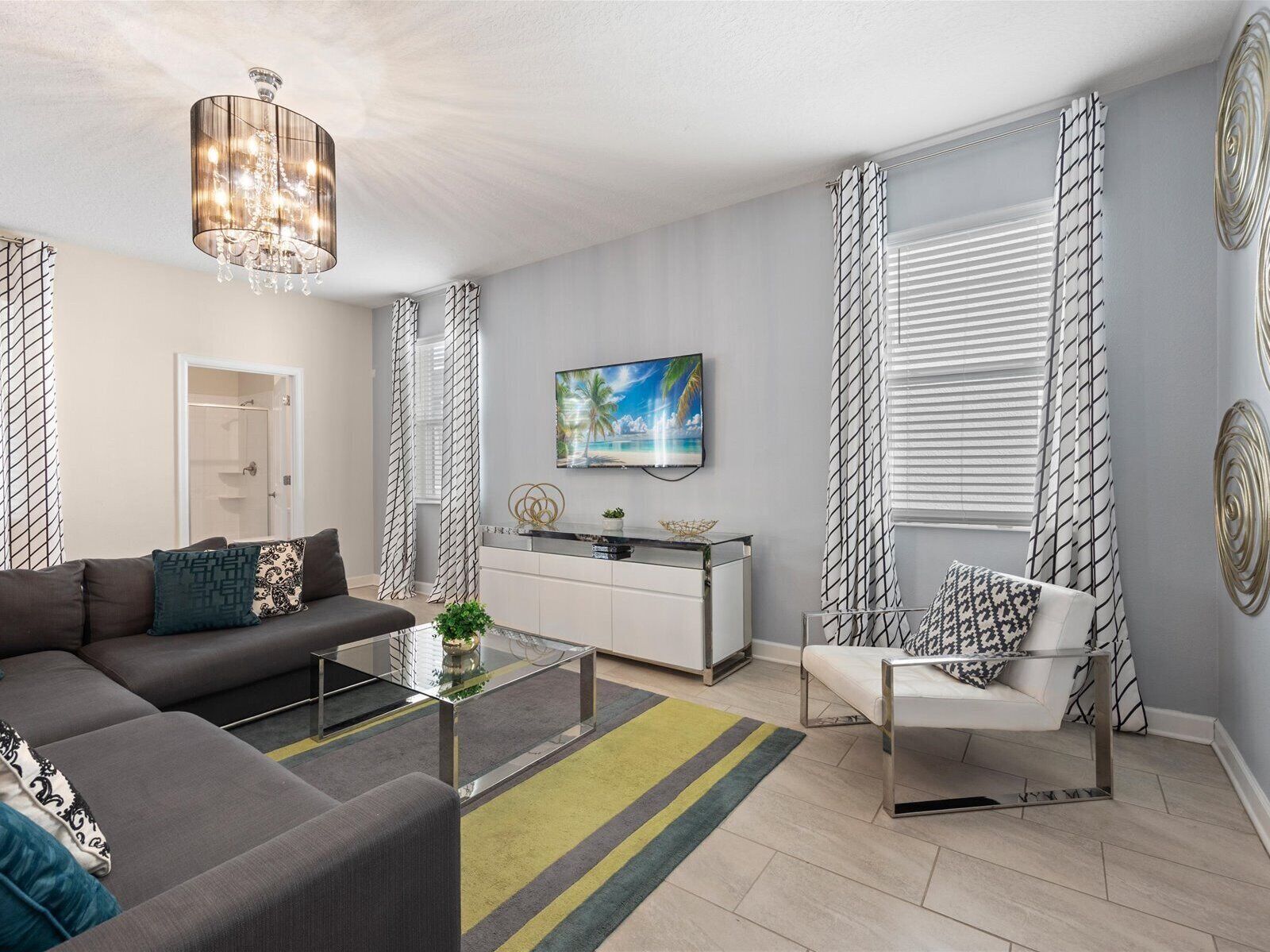 Un salon moderne avec un canapé, une table basse et un téléviseur fixé au mur.
