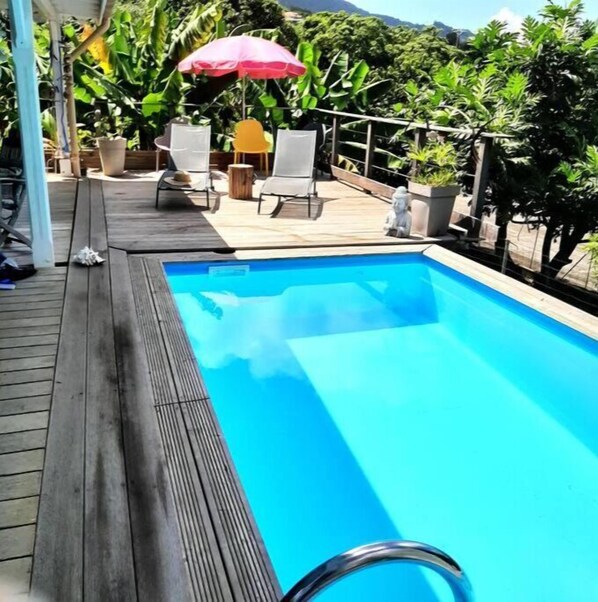 Relax by the pool surrounded by lush greenery and enjoy the serene atmosphere.