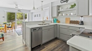 Une cuisine moderne avec des meubles gris, un lave-vaisselle et un espace dédié à la préparation du café.