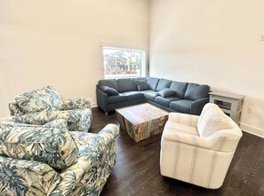 A living room with a sectional sofa, two armchairs, and a coffee table.