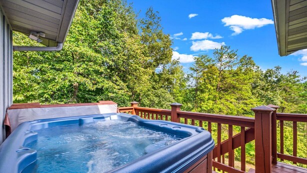 A hot tub on a wooden deck with a view of lush green trees. - New! Private 2BR Cabin w/Hot Tub*Central Location (Sevierville)