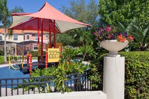 Children can play under the shaded canopy and climb the colorful play structure in this garden oasis.