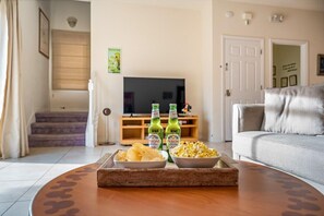 Relax in this stylish living room with a flat-screen TV, comfortable sofa, and a coffee table perfect for snacking.