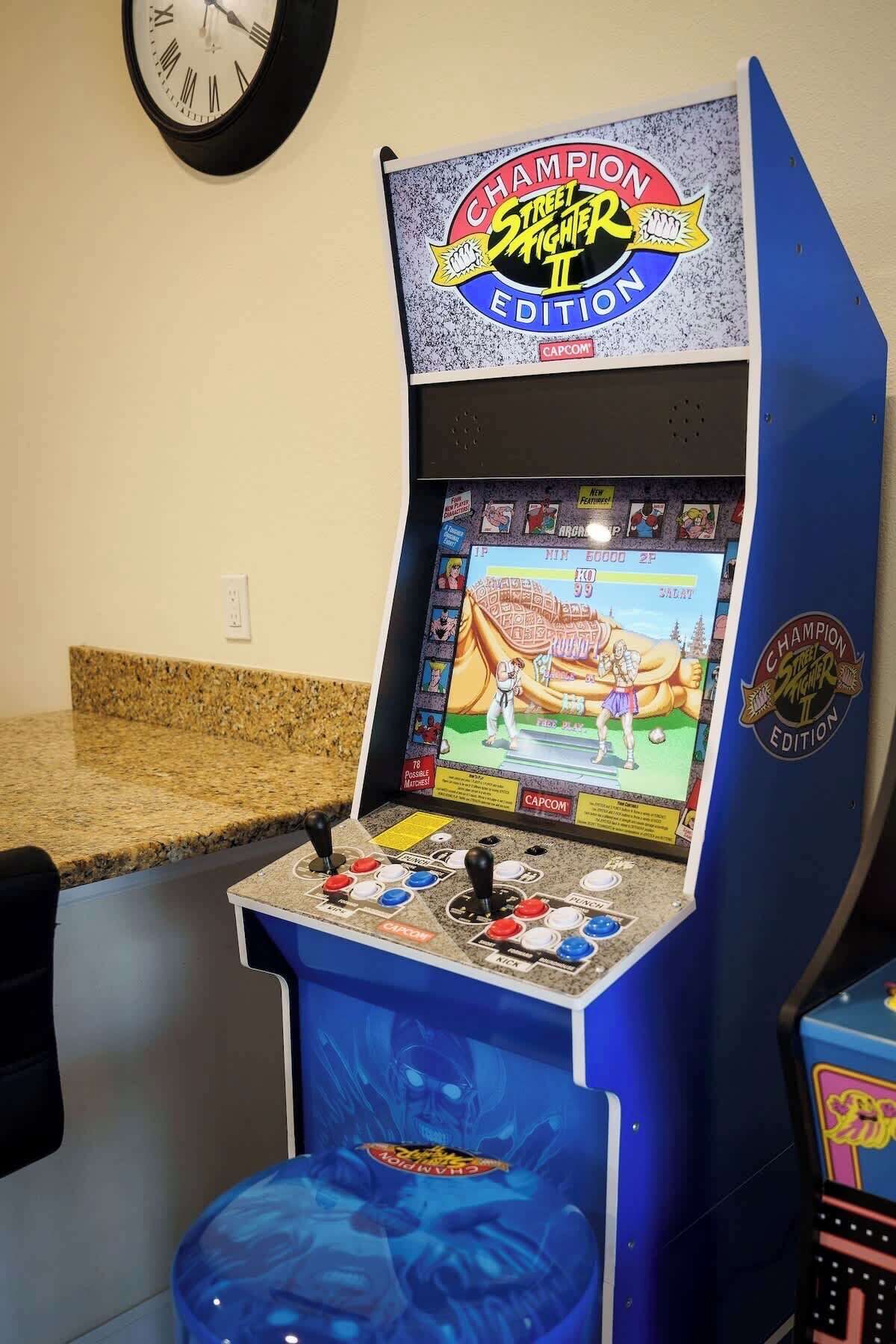 Une borne d’arcade de jeu vidéo portant l’inscription « Champion Street Fighter II Edition » et dont l’écran affiche un personnage de jeu de combat.
