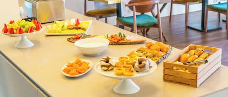 A buffet with various food items and a stone wall in the background.