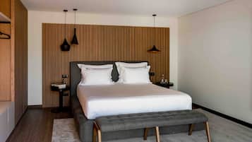 A modern bedroom with a large bed, bedside tables, and a bench.