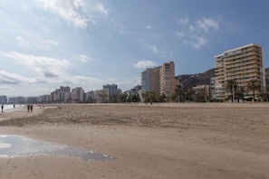 Une plage de sable avec des bâtiments en arrière-plan.