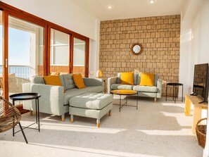 Un salon moderne avec deux canapés, une table basse et un téléviseur.