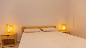 A single bed with two white pillows and two bedside tables with lamps. - Cullera Beachfront Apartment (Cullera)