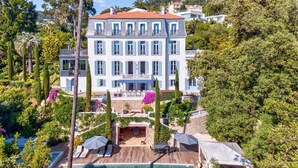 A large, multi-story building with a swimming pool, surrounded by lush greenery and a well-maintained garden. - Château Les Alouettes (Cannes)