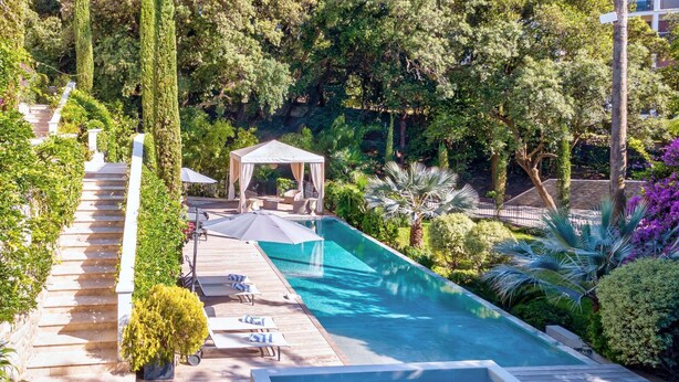 A pool area with a wooden deck, lounge chairs, and a gazebo. - Château Les Alouettes (Cannes)
