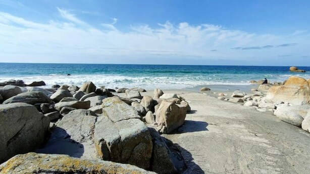 Una playa rocosa con grandes rocas y una vista despejada del océano.