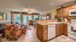 A compact living space with a kitchenette, a sofa, a dining area, and a ceiling fan.