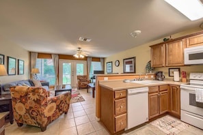 A compact living space with a kitchenette, a sofa, a dining area, and a ceiling fan.