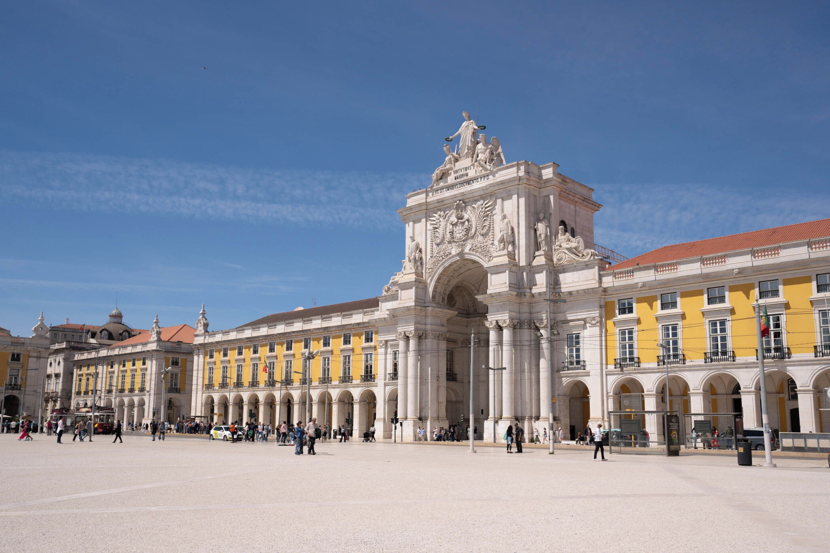 A historic building with classical architecture, featuring a central archway and statues.