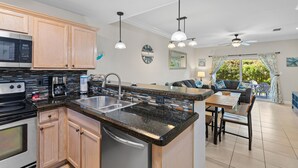 A modern kitchen with granite countertops, stainless steel appliances, and wooden cabinets.