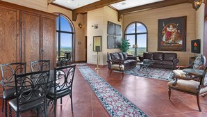 A spacious living room with a large wooden cabinet, leather sofas, and a view of the outdoors.