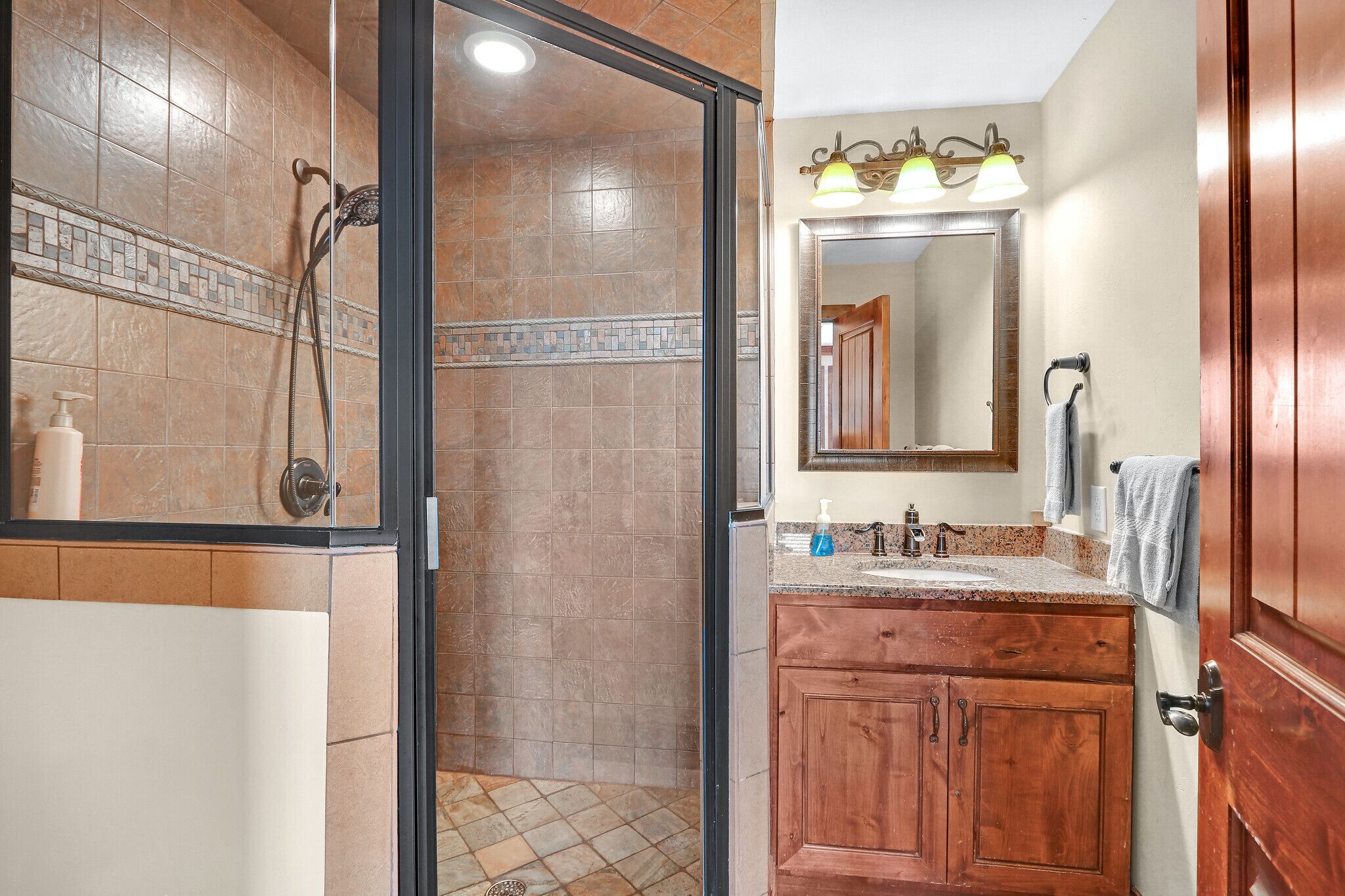 Une salle de bain avec une douche, un lavabo et un miroir.