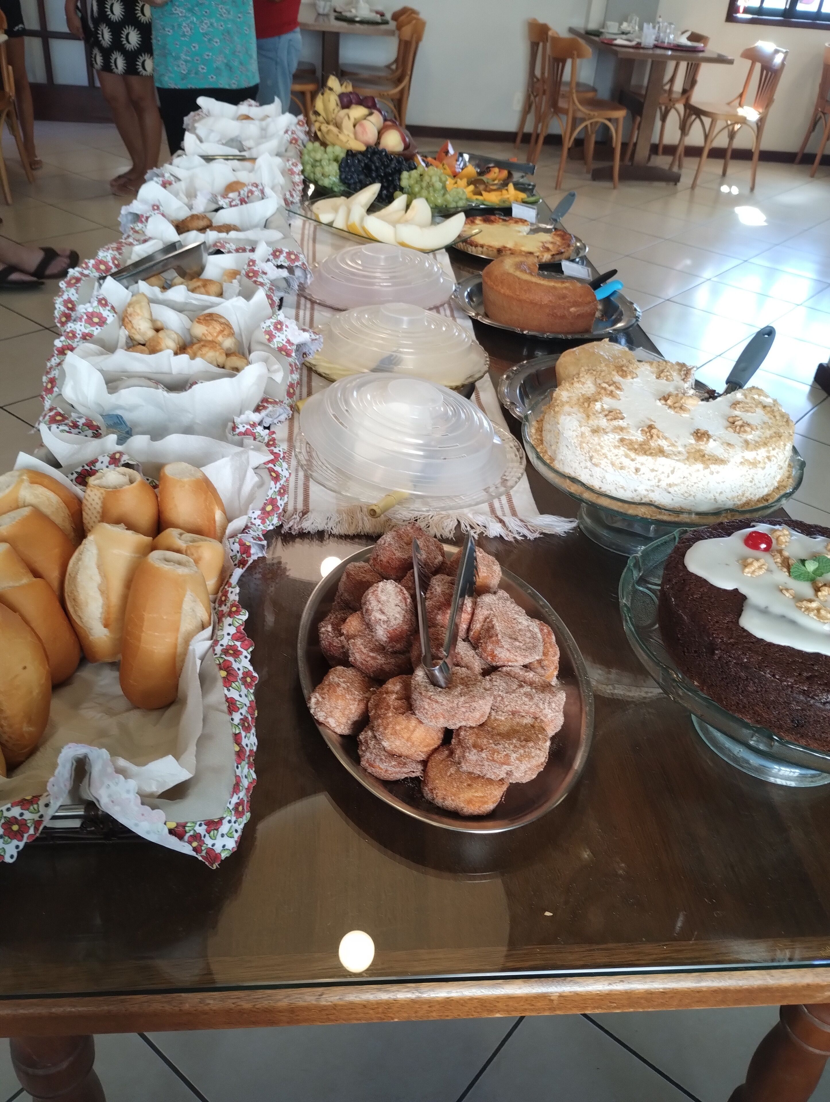 Una mesa de buffet con diferentes opciones de comida, incluyendo pasteles, frutas y tartas.