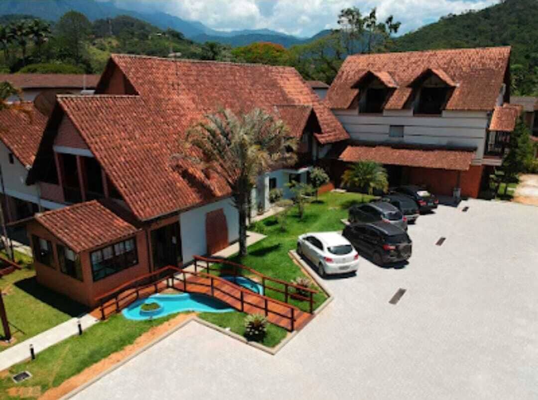 A resort with multiple buildings, a swimming pool, and a parking area.