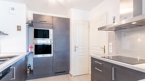 Una cocina moderna con electrodomésticos de acero inoxidable, horno empotrado y estufa a gas.