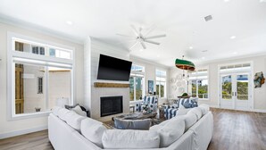 A spacious living room with a large sectional sofa, a fireplace, and a flat-screen TV. - The Boat House at Kiva Dunes (Gulf Shores)