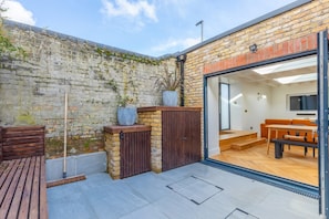 Experience a cozy home-like atmosphere in this compact living space with a brick exterior and lush greenery.