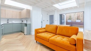 A modern kitchen with light wood cabinets, a white countertop, and a built-in oven. - Luxuriously Compact 1BD Eco Home Clapham Common! (London)