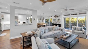 A spacious living room with a large sofa, a coffee table, and a dining area in the background.
