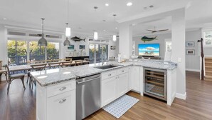 A modern kitchen with white cabinetry, a granite countertop, and stainless steel appliances.