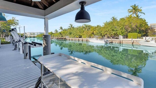 A swimming pool area with lounge chairs and a ceiling fan.