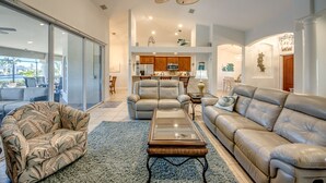 A spacious living room with a large ceiling fan, a sofa, a chair, and a coffee table.