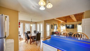 A kitchen with a blue countertop, wooden dining table, chairs, and a refrigerator. - Nautical Retreat at Kudzu Cove Cabins Resort (Guntersville)