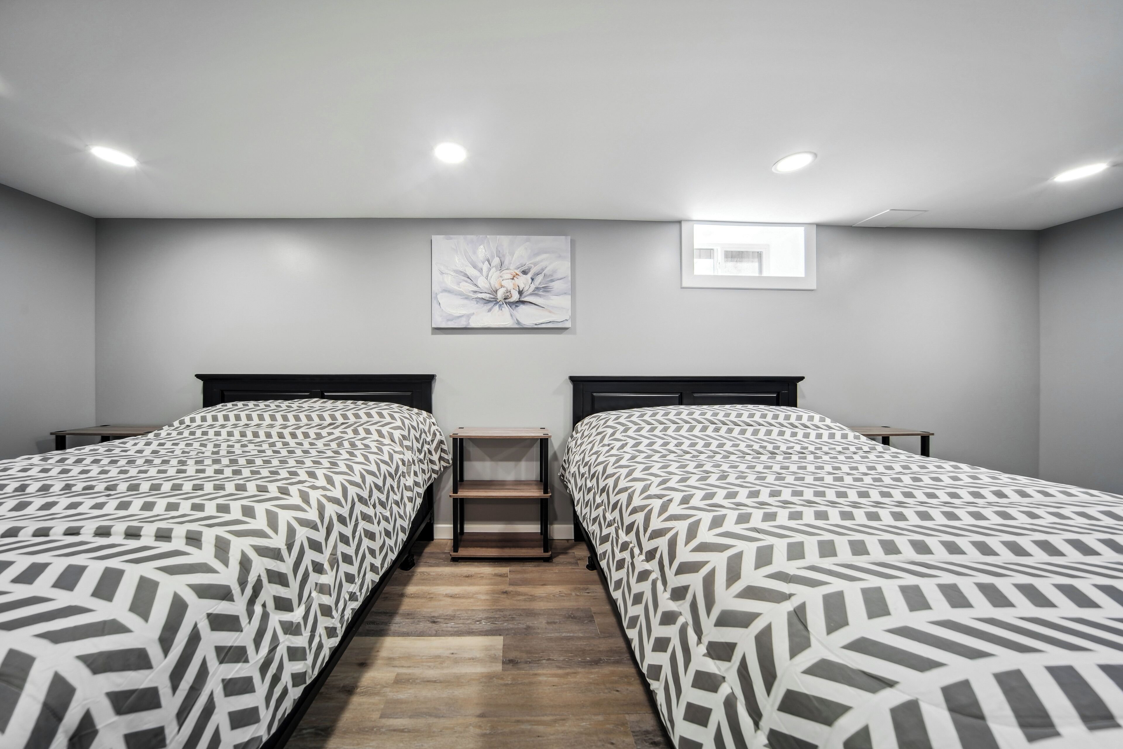 A room with two beds, a small table, and a window.